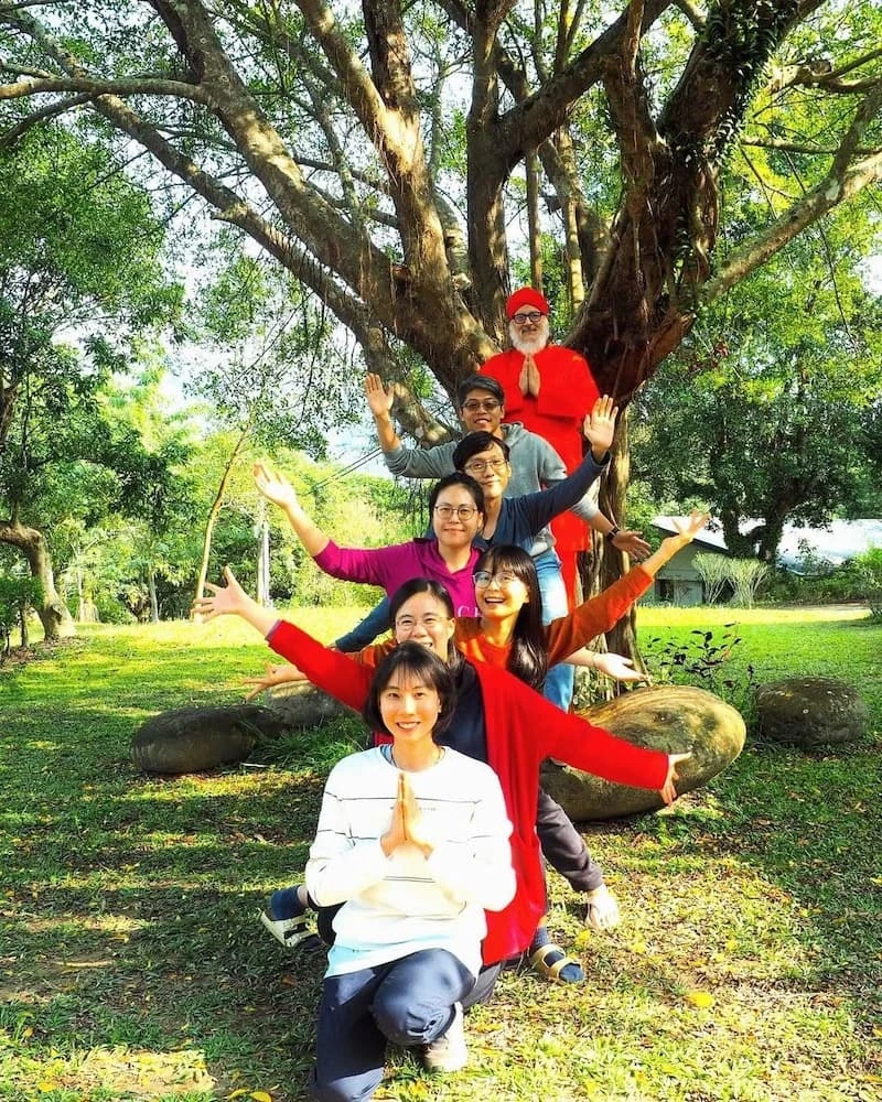 The Suruci team gathered playfully around a large tree in the garden