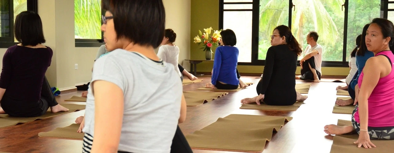 A group practicing seated yoga together in the indoor studio