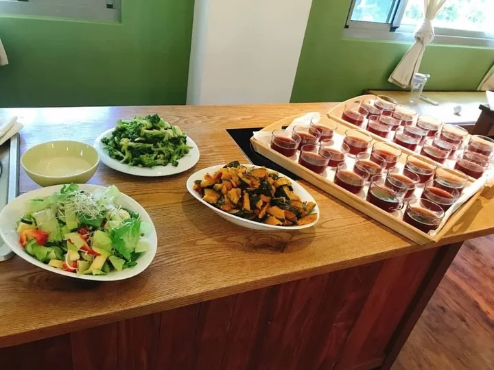 Vegetarian dishes and fresh juices laid out on a wooden serving table
